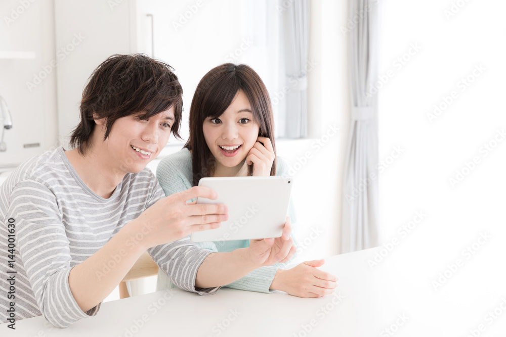 young asian couple using smart phone in kitchen young asian couple using smart phone in kitchen