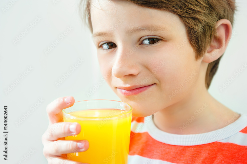 Smiling boy enjoying with glass of yellow juice Smiling boy enjoying with glass of yellow juice