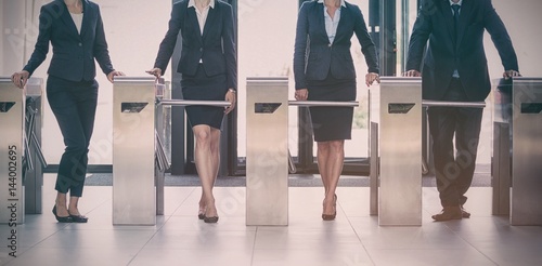 Businesspeople standing at turnstile gate photo