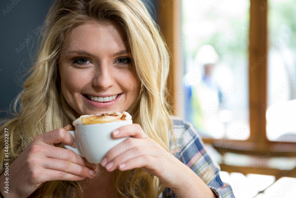 Smiling young woman having coffee in cafe Smiling young woman having coffee in cafe