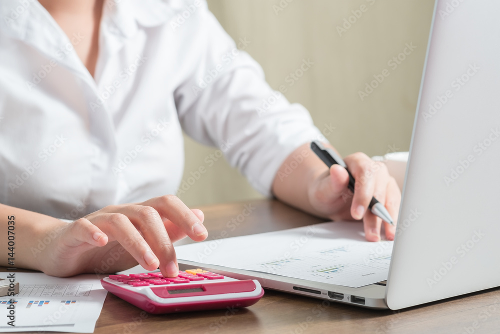 Fototapeta premium Close up female accountant or banker making calculations. Savings, finances and economy concept