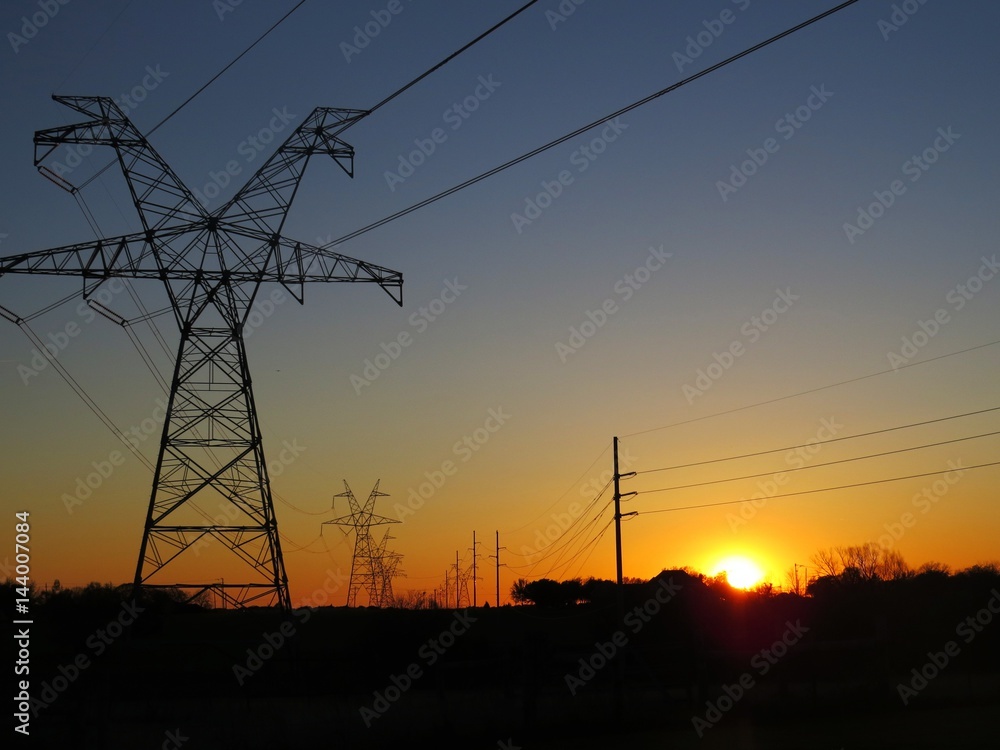 View of sunset looking through powerlines