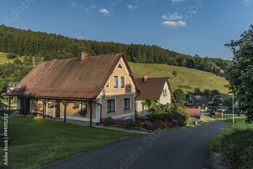 Sunny summer day in Krkonose mountains with countryside house