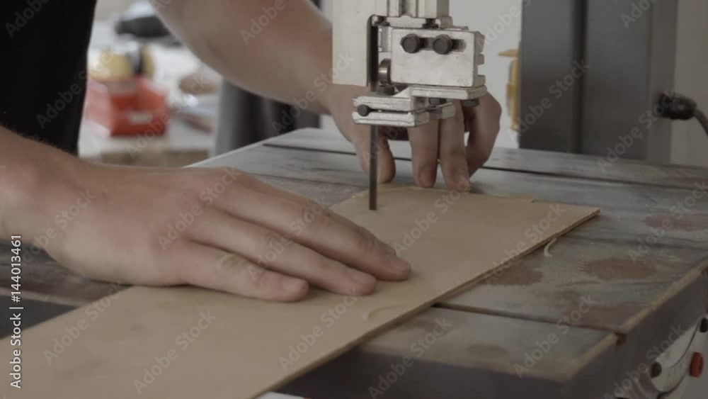 man sawing a wooden plate with a jigsaw
man sawing a wooden plate with a jigsaw