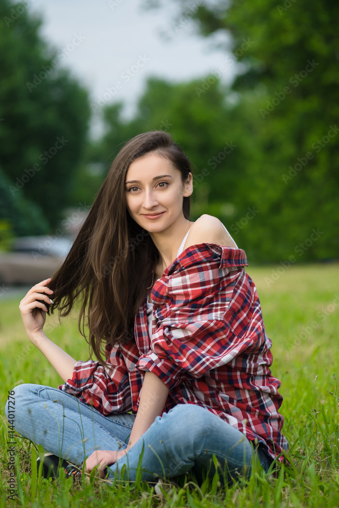 woman in jeans and shirt resting. Lays on the fresh grass woman in jeans and shirt resting. Lays on the fresh grass