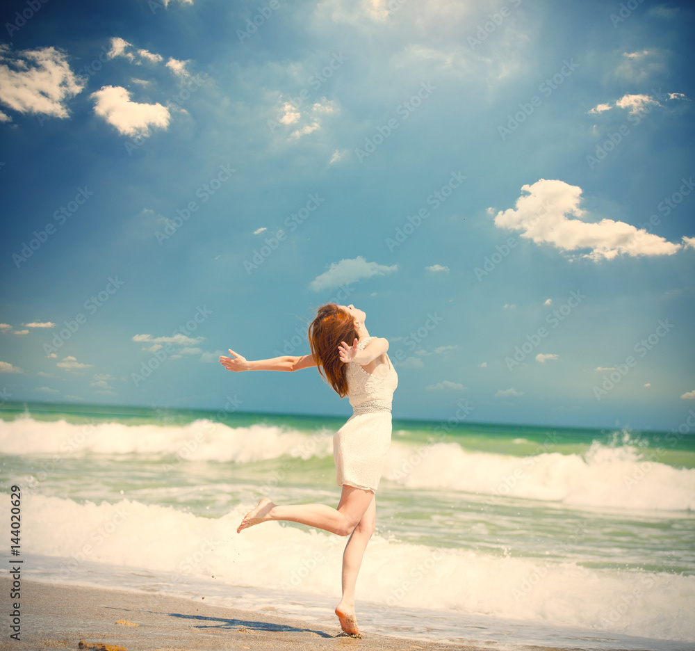 photo of beautiful young woman jumping on the sunny coast on the sky and sea backgrond photo of beautiful young woman jumping on the sunny coast on the sky and sea backgrond
