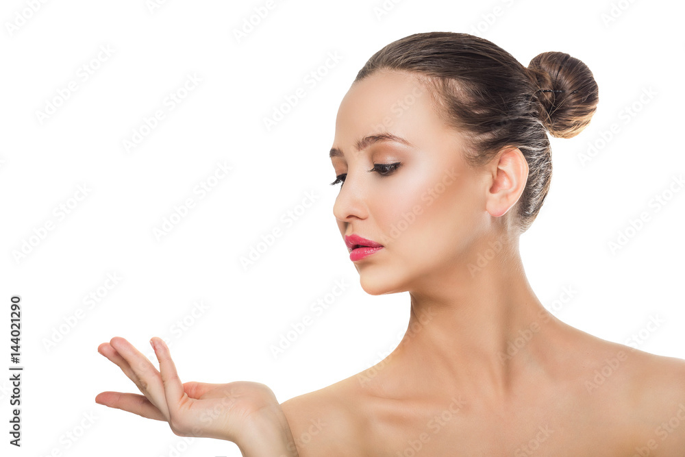 beautiful brunette girl with delicate make up on a white background with an open hand looking at his hands shows the isolate Spa care skin cream freshness