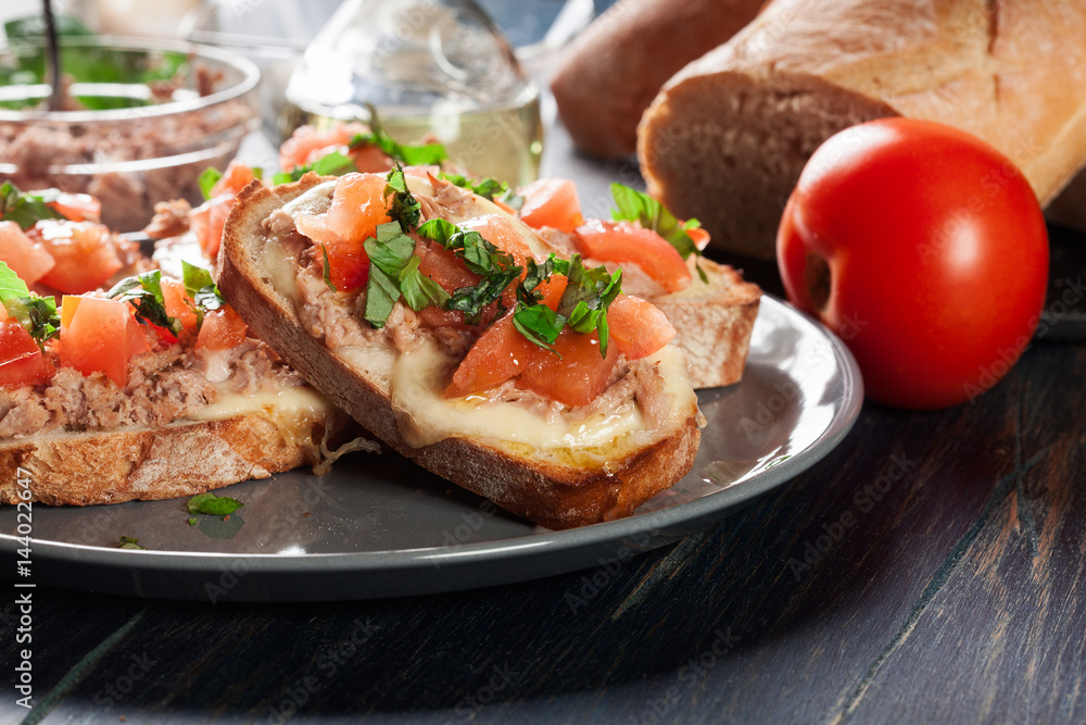 Appetizer bruschetta with tuna, mozarella cheese and tomatoes