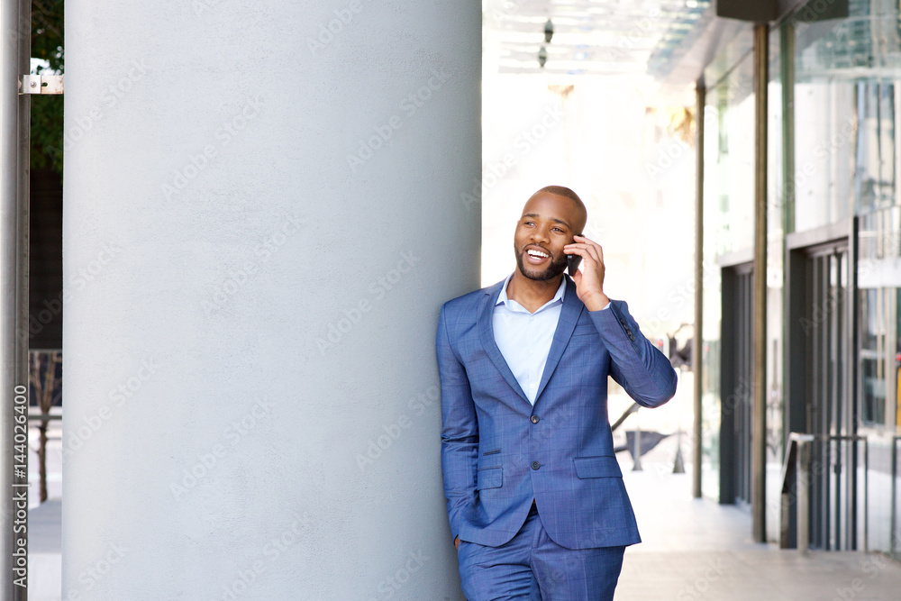 young african businessman talking on cell phone while in the city young african businessman talking on cell phone while in the city