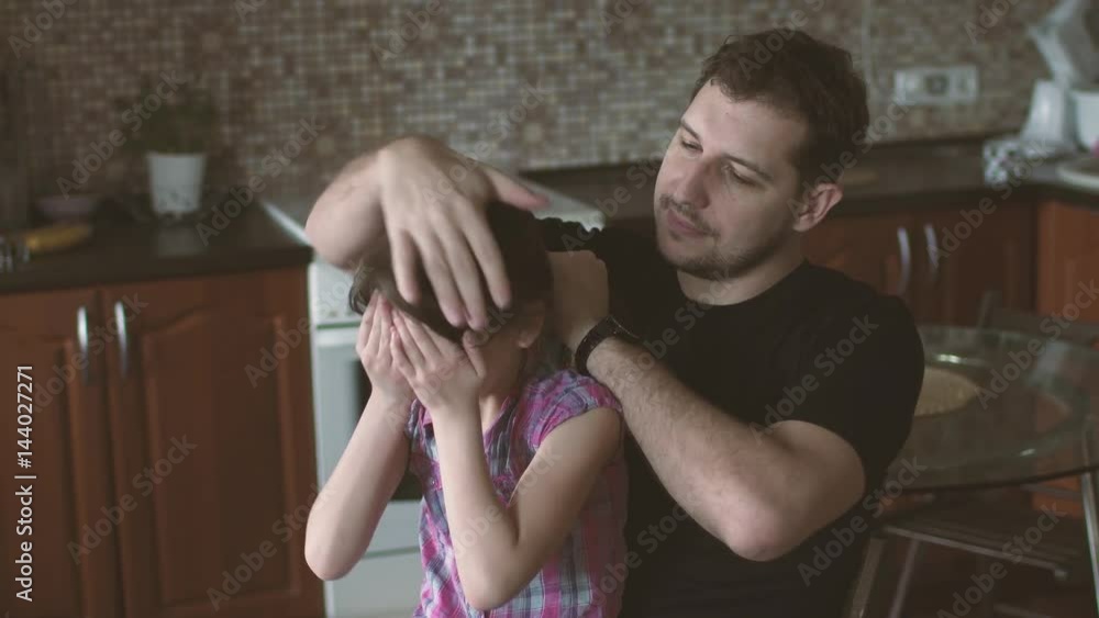 father plaits pigtails to a small daughter. little girl and her father spend time together and have fun father plaits pigtails to a small daughter. little girl and her father spend time together and have fun