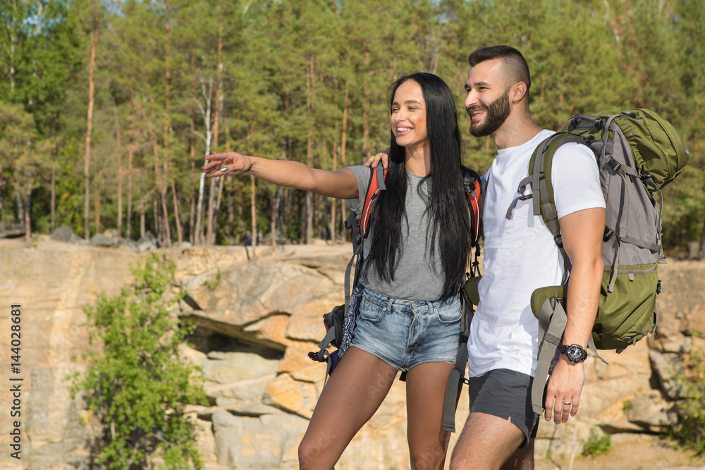 Happy young couple enjoying the hike in the woods Happy young couple enjoying the hike in the woods