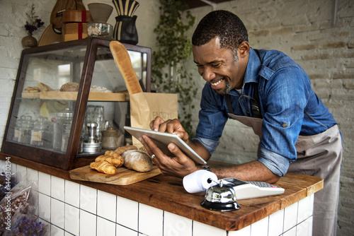 Papier peint Man using devices for online business order at bakehouse