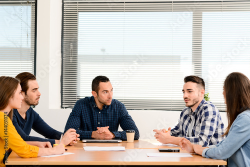 young casual and dynamic new business people team man and woman discussing on informal meeting with the company manager in office