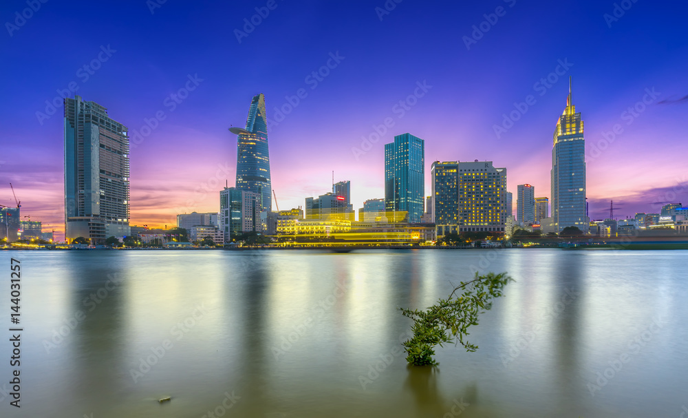 Ho Chi Minh City, Vietnam - March 25th, 2017: Riverside City sunrays clouds in the sky at end of day brighter coal sparkling skyscrapers along beautiful river in Ho Chi Minh City, Vietnam