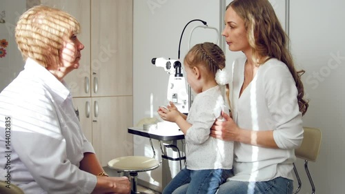 Child's ophthalmology - check up for eyesight's healthcare - optometrist diagnosis little girl photo