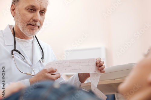 Obraz na plátně Responsible clever cardiologist explaining the results to his patient