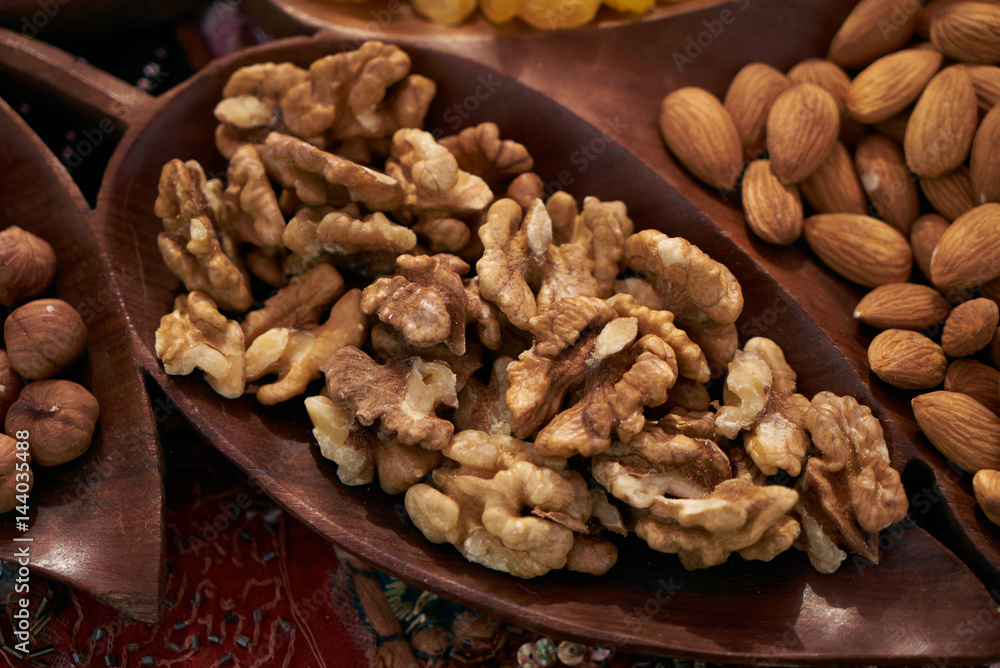Set of different nuts, almonds, walnuts, hazelnuts in brown wooden bowl. Close-up Set of different nuts, almonds, walnuts, hazelnuts in brown wooden bowl. Close-up