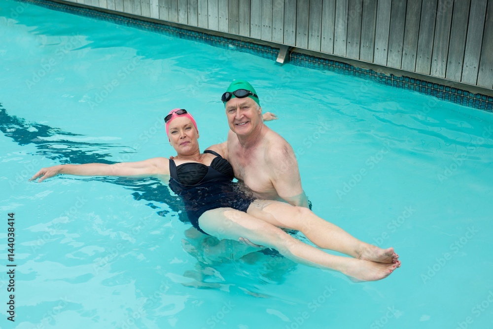 Loving mature couple enjoying in swimming pool