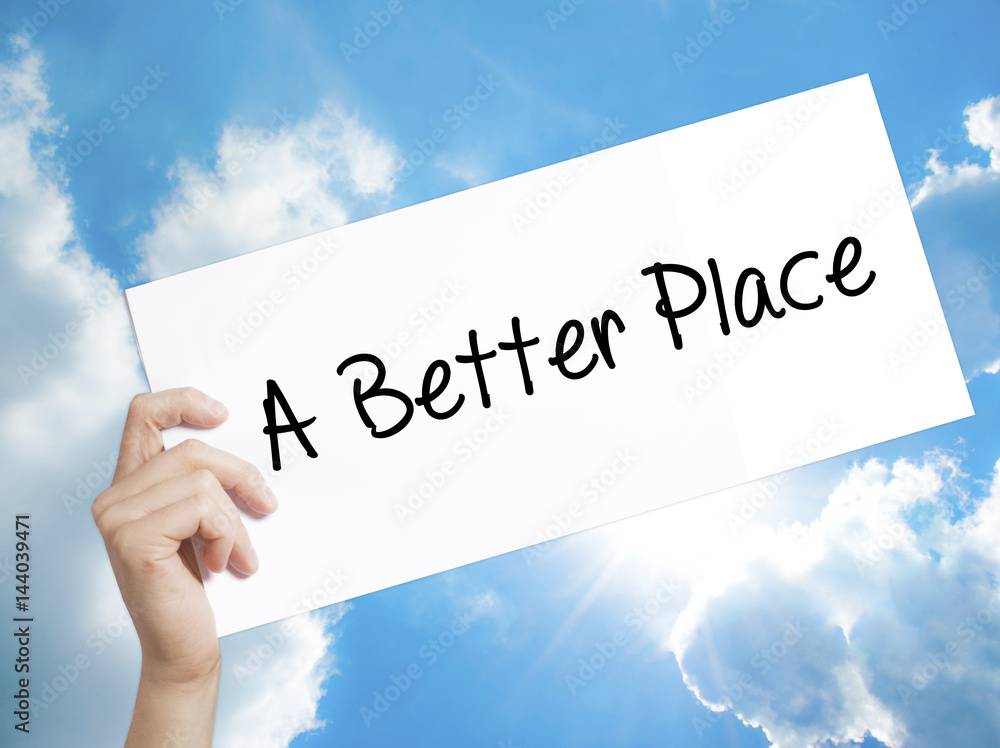 A Better Place Sign on white paper. Man Hand Holding Paper with text. Isolated on sky background A Better Place Sign on white paper. Man Hand Holding Paper with text. Isolated on sky background