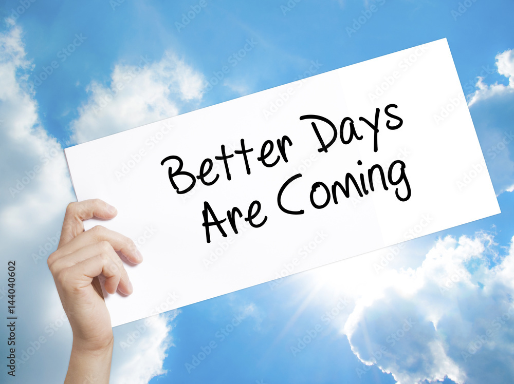 Better Days Are Coming Sign on white paper. Man Hand Holding Paper with text. Isolated on sky background. Better Days Are Coming Sign on white paper. Man Hand Holding Paper with text. Isolated on sky background.