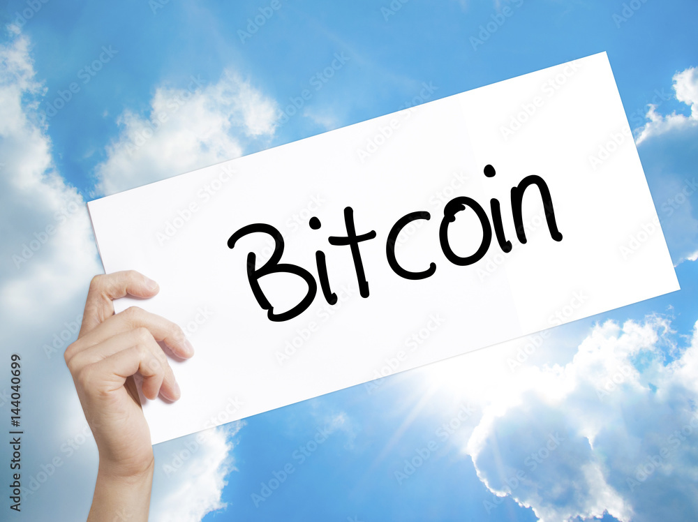 Bitcoin Sign on white paper. Man Hand Holding Paper with text. Isolated on sky background. Bitcoin Sign on white paper. Man Hand Holding Paper with text. Isolated on sky background.