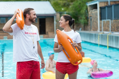 Lifeguards holding rescue cans at poolside