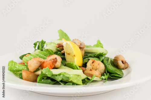 Sea salad with scallops, prawns, squid, cuttlefish, in duet with lettuce and cucumber, seasoned with olive oil and Provence herbs