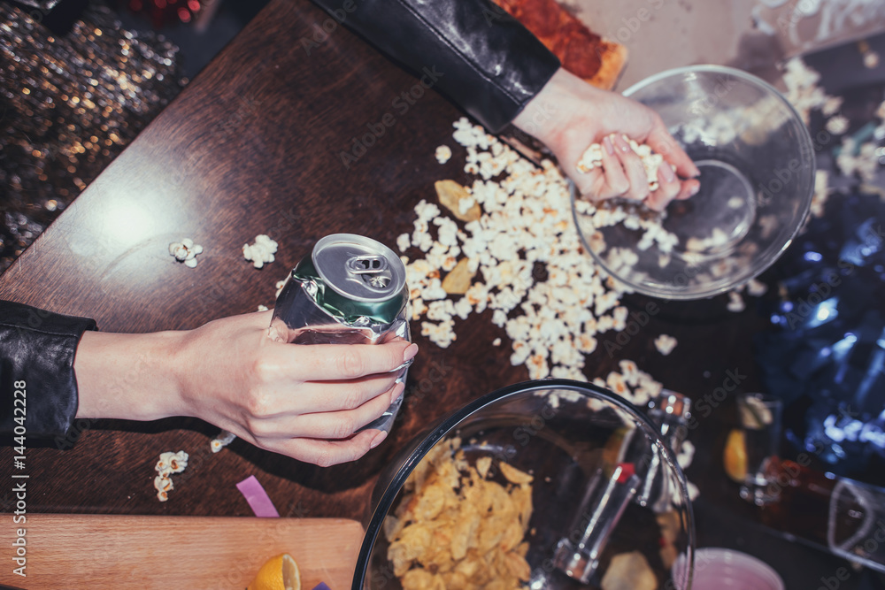 Fototapeta premium woman eating popcorn in messy room after party