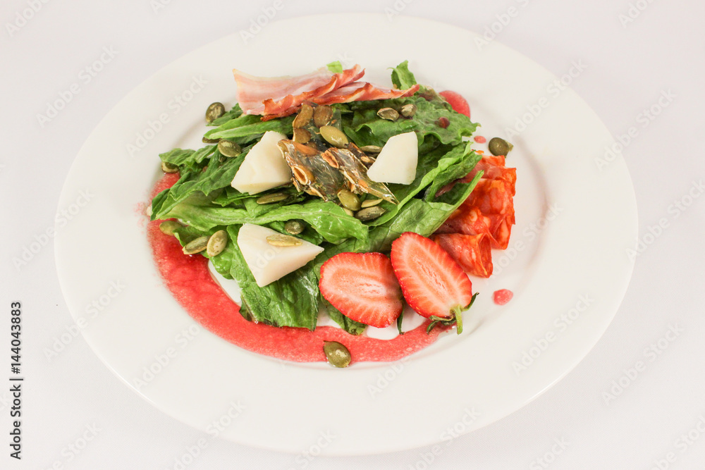 Mix of hot sausages with bacon on a cushion of lettuce leaves, in a duet with parmesan and strawberries, garnished with pumpkin seeds, dressed with raspberry sauce Mix of hot sausages with bacon on a cushion of lettuce leaves, in a duet with parmesan and strawberries, garnished with pumpkin seeds, dressed with raspberry sauce