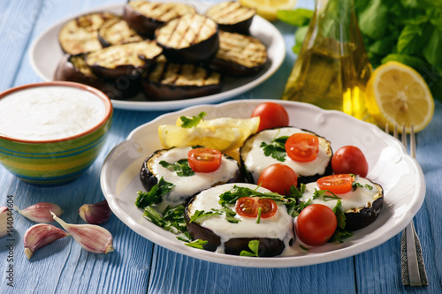 Grilled eggplants with yogurt dip and tomatoes.