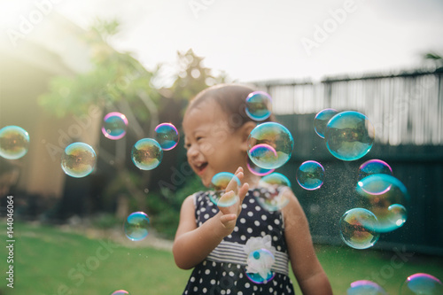 little girl trying to catch soap bubbles