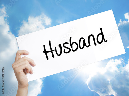 Husband Sign on white paper. Man Hand Holding Paper with text. Isolated on sky background.