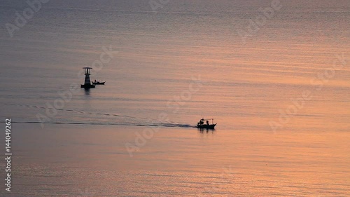 aerial view silhouette sunrise lighthouse and local fishery boat sailing in the morning at Hua Hin, Thailand