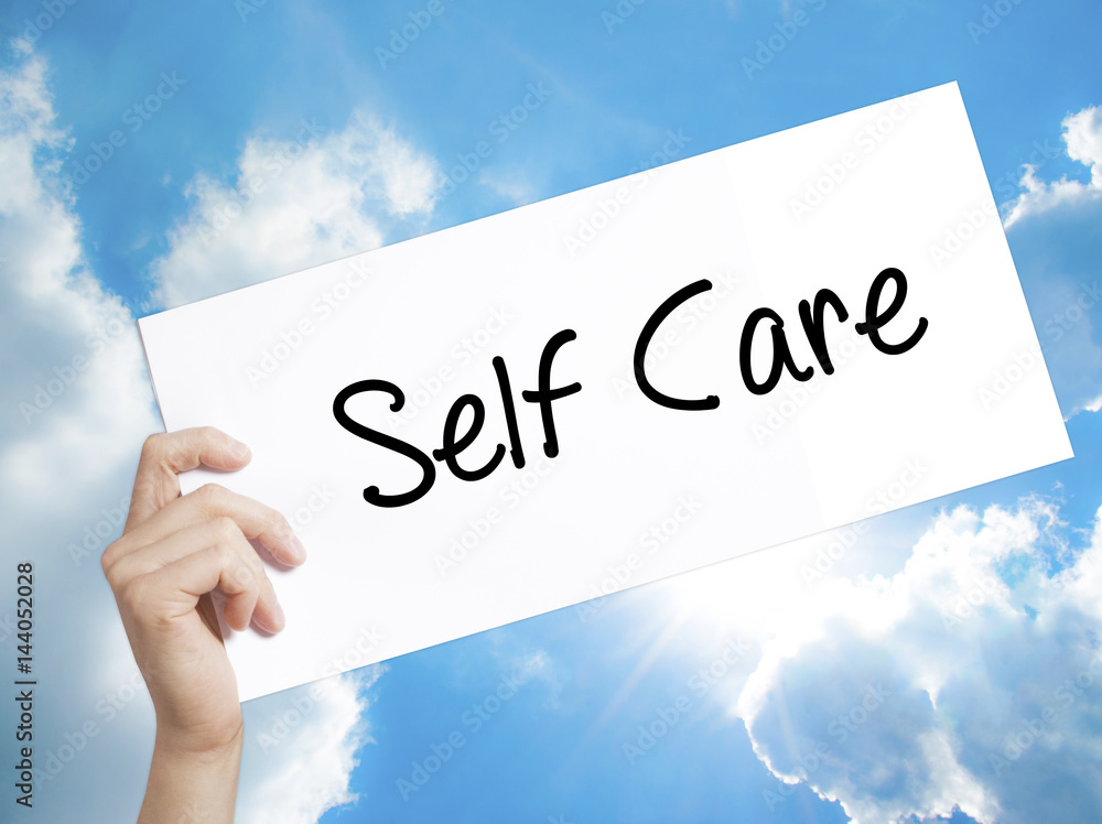 Self Care Sign on white paper. Man Hand Holding Paper with text. Isolated on sky background Self Care Sign on white paper. Man Hand Holding Paper with text. Isolated on sky background