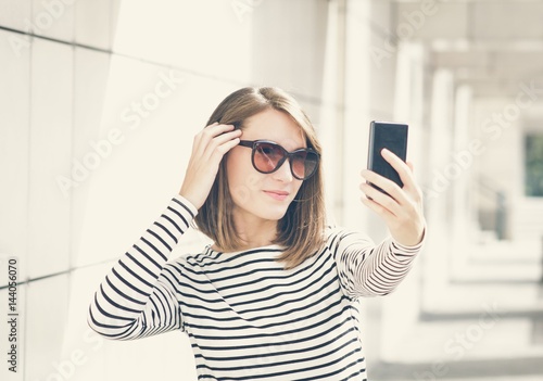 Young woman taking selfie on mobile phone