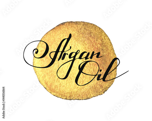 Hand written words Argan Oil on golden paint splash on white background