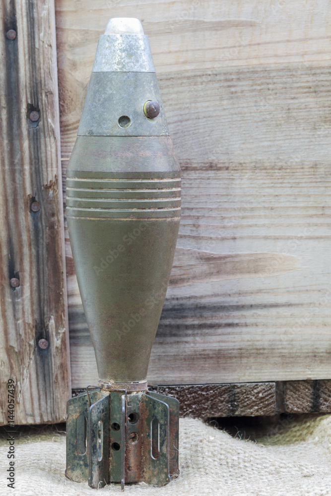60 mm. mortar big bullet on wood background for learning