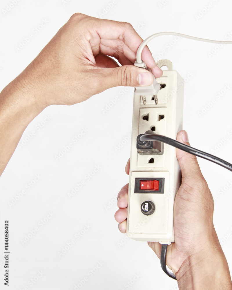 Man's hand inserting an electrical plug into multiple socket bar on white background. Man's hand inserting an electrical plug into multiple socket bar on white background.