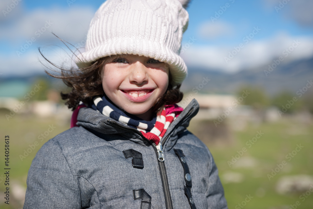 Close-up of a little girl with wool cap and scarf in the field Close-up of a little girl with wool cap and scarf in the field