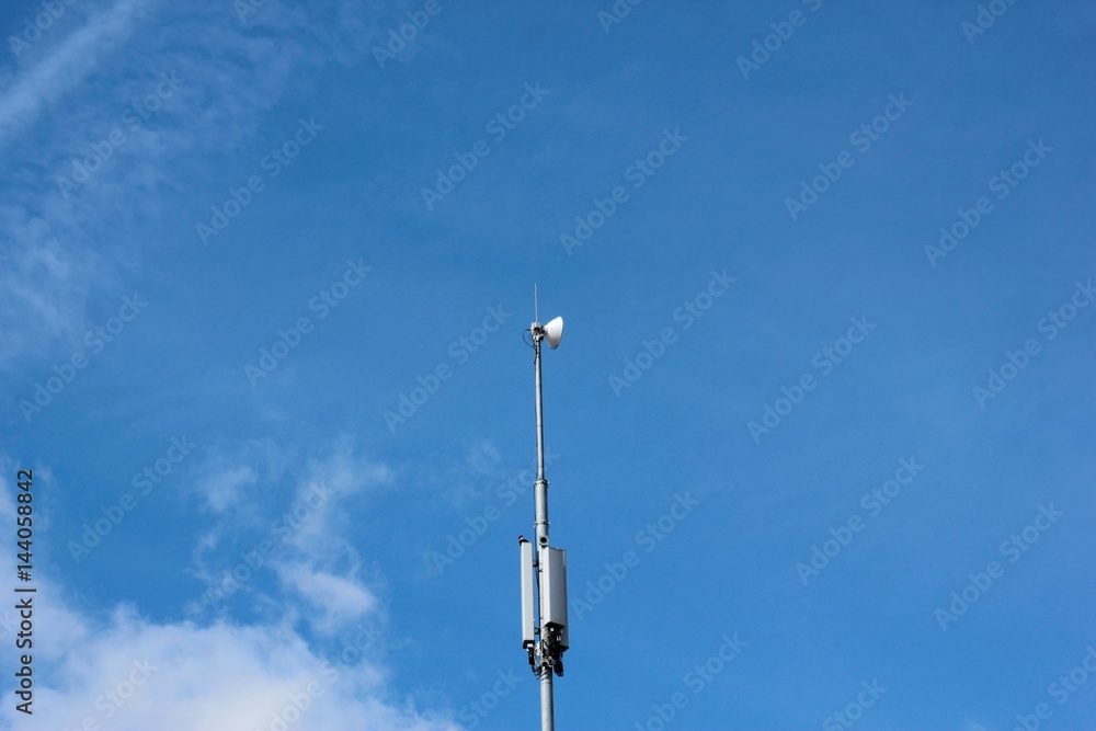 A cell phone tower on blue sky background