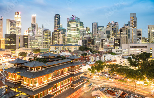 High view of Singapore skyline with skyscrapers and Tooth Relic Temple at blue hour - World famous top south east Asia destinations - City panorama on vivid warm filter with nightscape color tones © Mirko Vitali