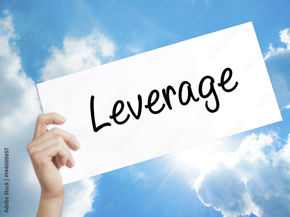 Leverage Sign on white paper. Man Hand Holding Paper with text. Isolated on sky background. Leverage Sign on white paper. Man Hand Holding Paper with text. Isolated on sky background.