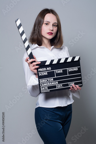 Young brunette in a white blouse with movie cracker photo