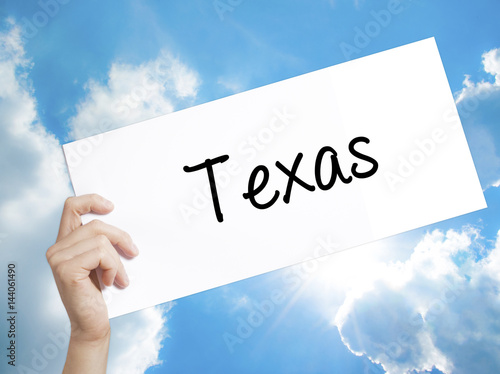 Texas  Sign on white paper. Man Hand Holding Paper with text. Isolated on sky background photo