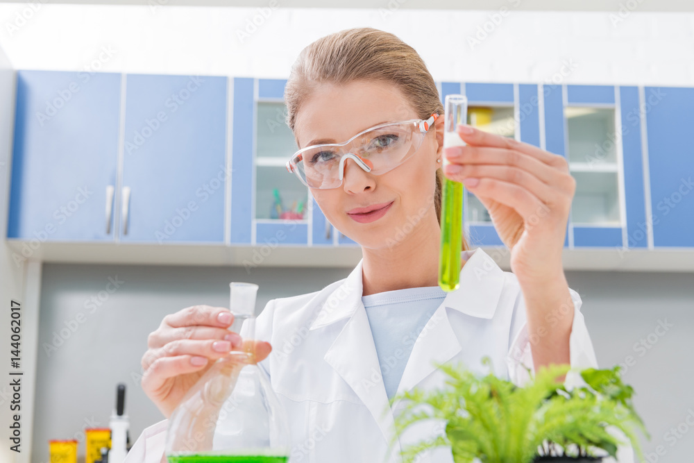 scientist holding tubes with reagents in laboratory looking at camera scientist holding tubes with reagents in laboratory looking at camera