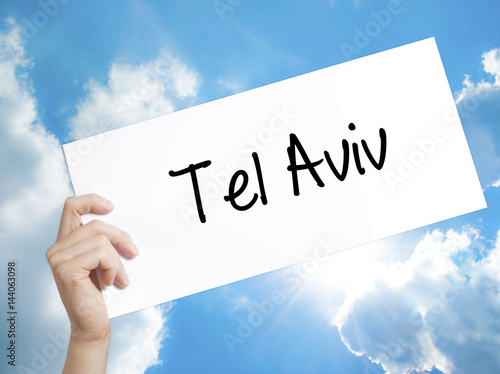 Tel Aviv  Sign on white paper. Man Hand Holding Paper with text. Isolated on sky background photo