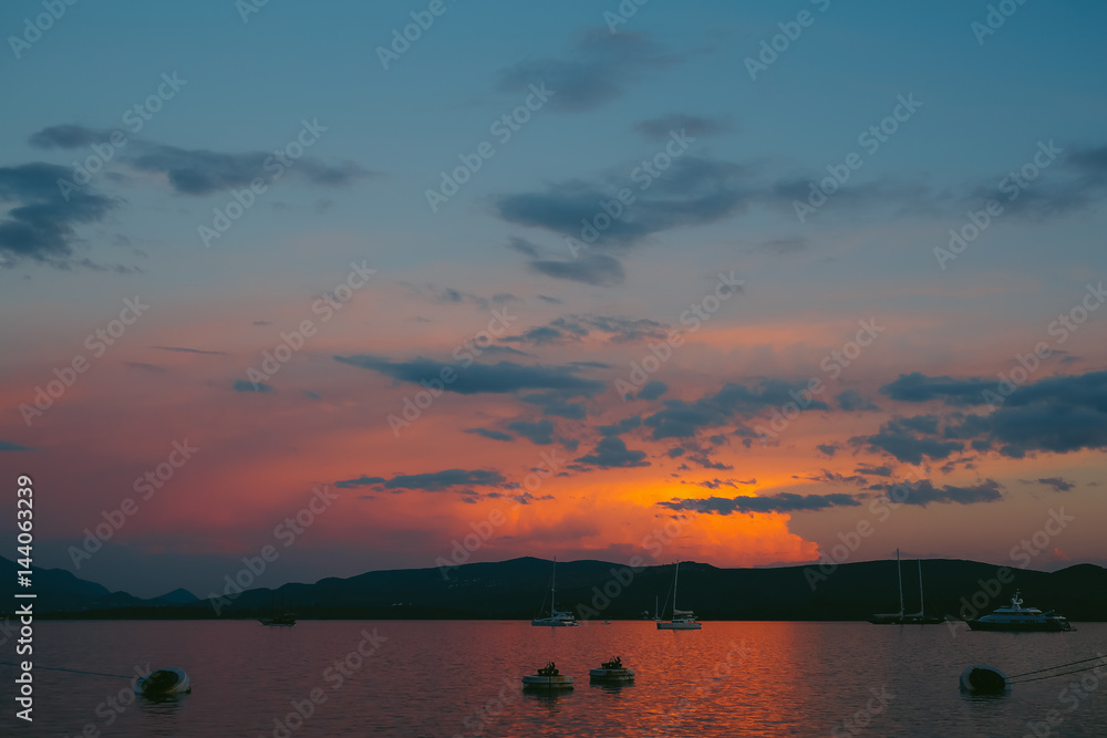 Yacht in the sea at sunset. Silhouette of a yacht on the background of the setting sun on the horizon