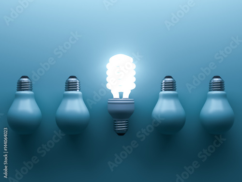 Energy saving light bulb up , one glowing fluorescent lightbulb standing out from unlit down incandescent bulbs on blue background , individuality and different creative idea concepts . 3D rendering. photo
