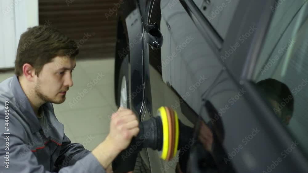 Master polishes the side of the body of a black SUV: the closeup and medium shot Master polishes the side of the body of a black SUV: the closeup and medium shot