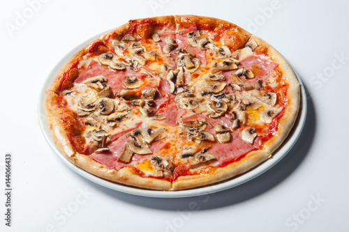 Italian delicious pizza with mushrooms and ham.